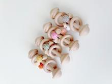 photograph of a selection of wooden baby rattles with beads on them
